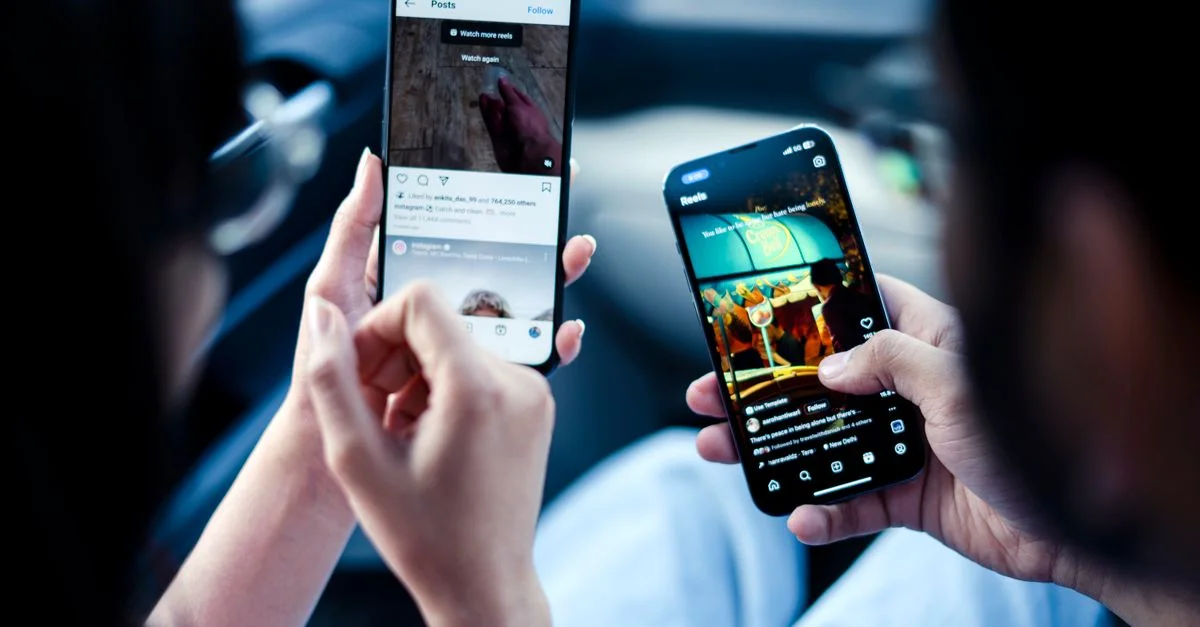 Un couple interagissant avec les réseaux sociaux sur des smartphones à l'intérieur, illustrant la connectivité numérique moderne.