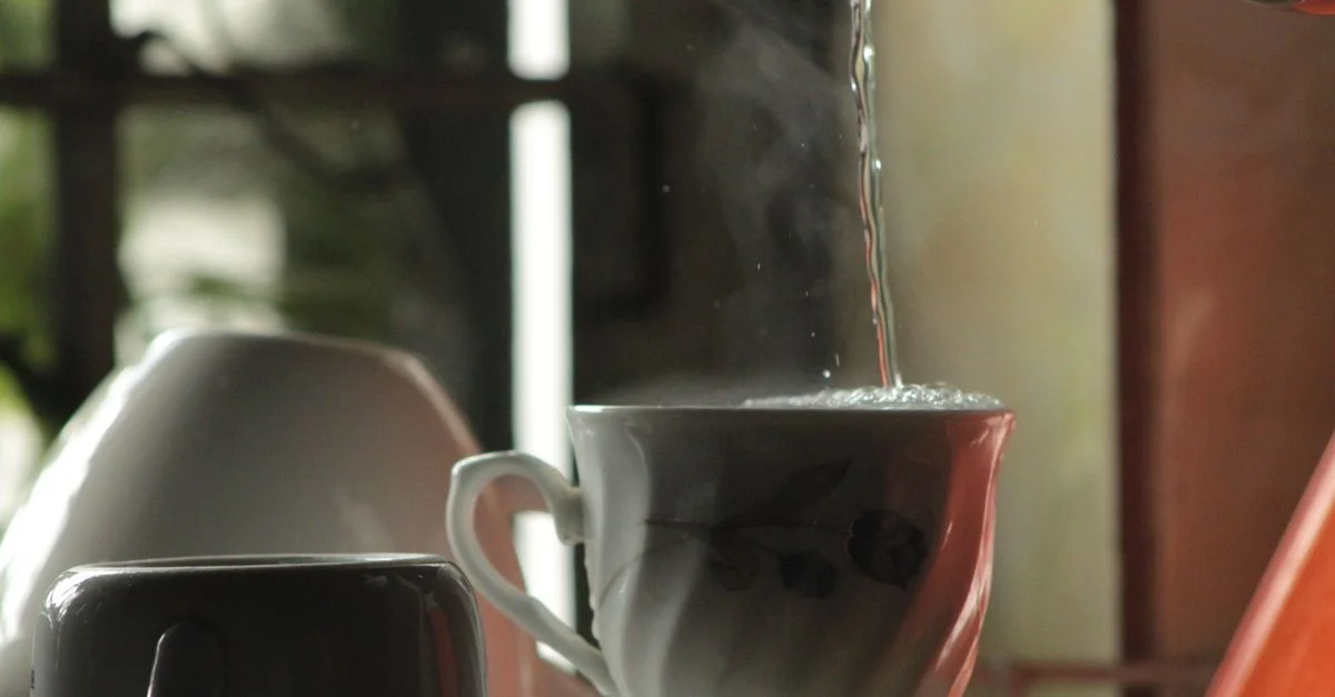 De l'eau chaude est versée dans une élégante tasse en céramique à l'intérieur.