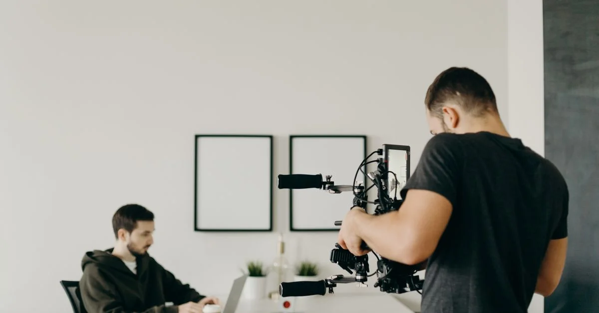 Un vidéaste capture un professionnel concentré travaillant sur un ordinateur portable dans un cadre de bureau à domicile stylé.